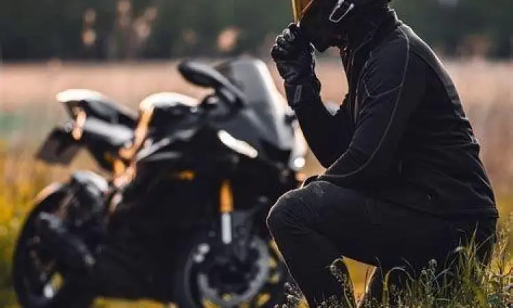 Seorang rider berpose dengan balaclava di depan motor