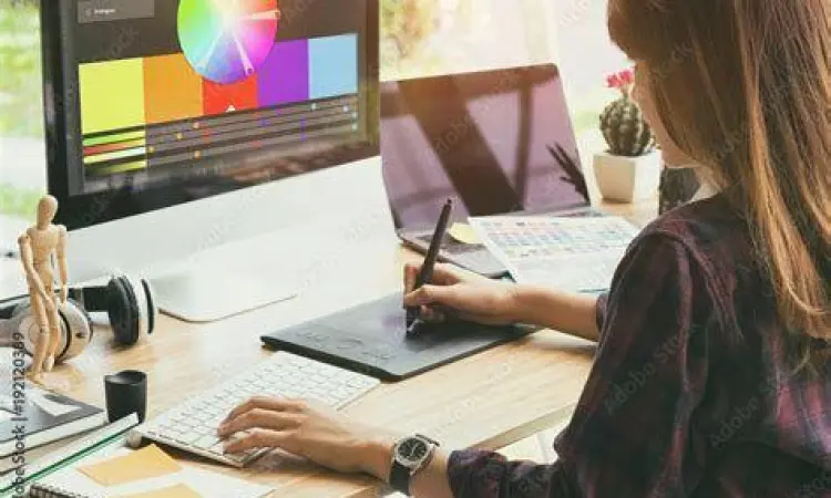 Desainer sedang bekerja menggunakan tablet grafis dan aplikasi editor