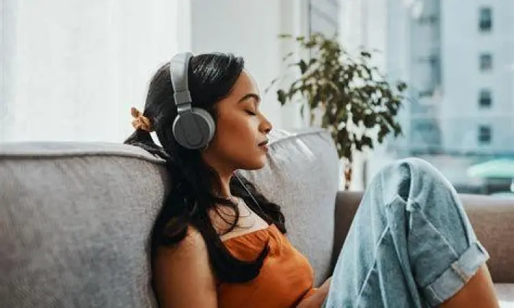 Relaksasi dengan Musik Seseorang bersantai mendengarkan musik dengan headphone