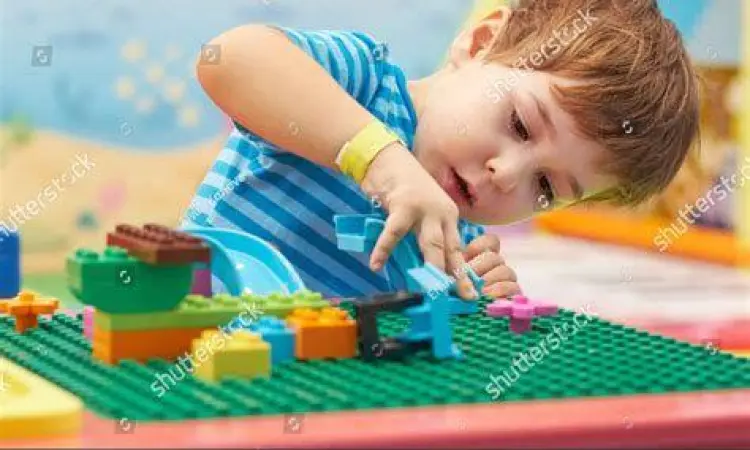 Anak sedang konsentrasi merakit Lego Juniors