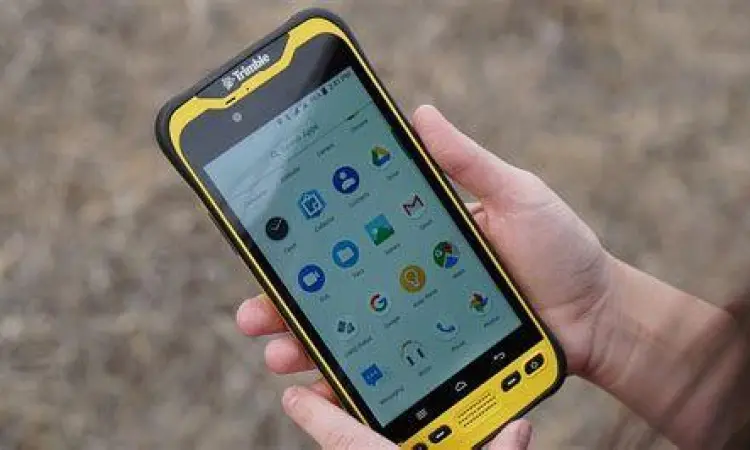 Petugas lapangan menggunakan smartphone untuk verifikasi data