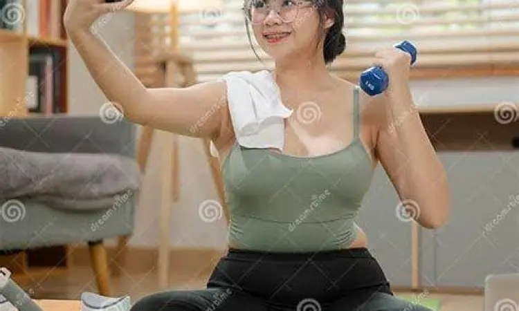 Seorang wanita sedang mengikuti instruksi latihan dari aplikasi olahraga