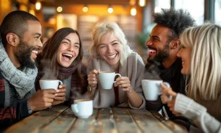 Sekelompok teman tertawa di kafe yang menggambarkan dinamika sosial