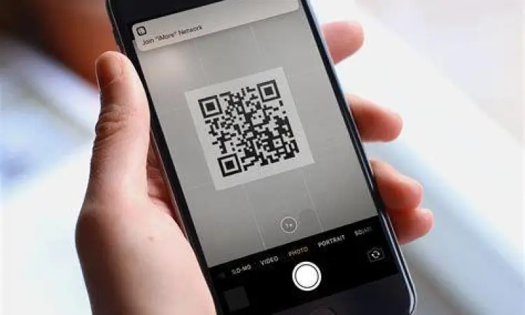 Kamera smartphone sedang fokus pada kode QR