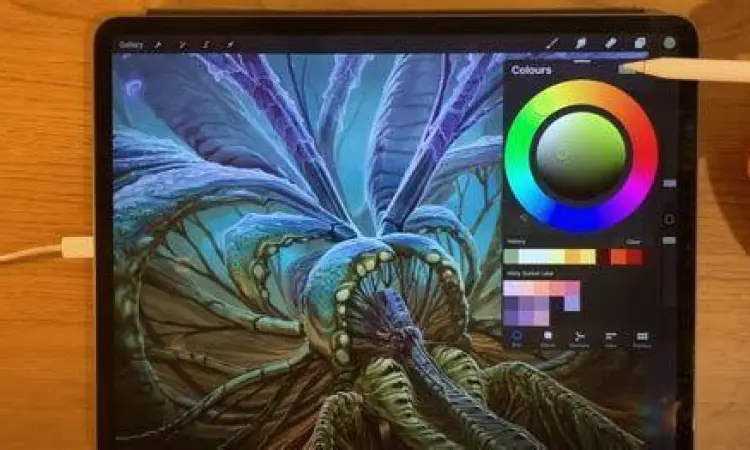 Seorang desainer menggunakan aplikasi Procreate di iPad untuk menggambar